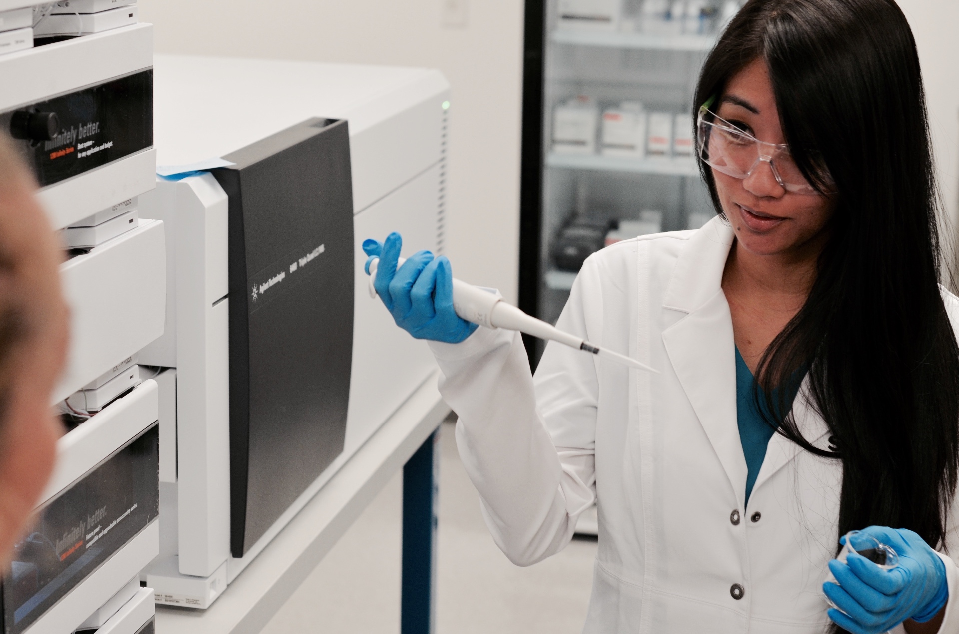 Lab technician operating Agilent Technologies LC-MS/MS system