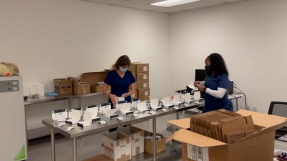 Staff assembling SynergyDx Home Collection Kits