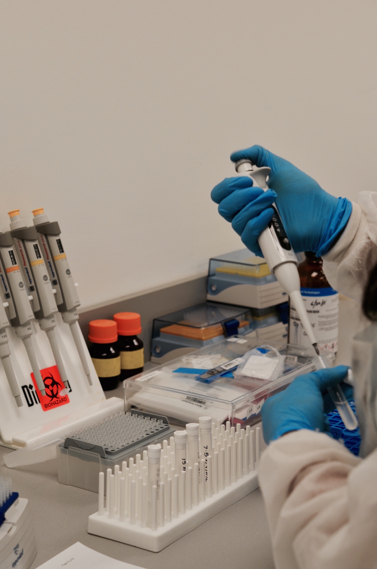 Lab technician pipetting samples in early Synergy lab